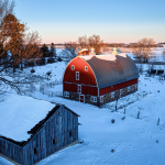 A scene of a farm in the snow